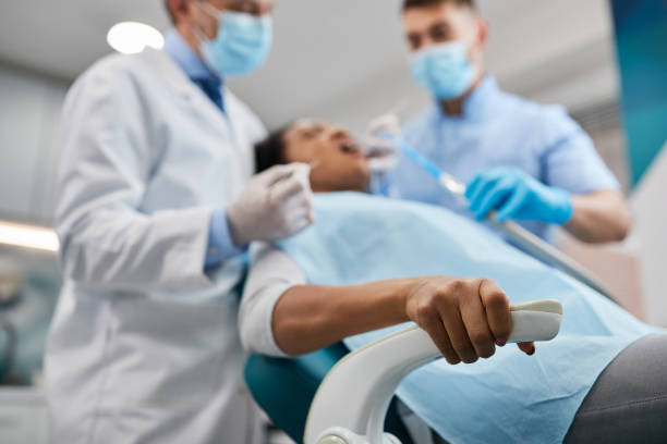close-up of woman holding tight to a chair during dental procedure