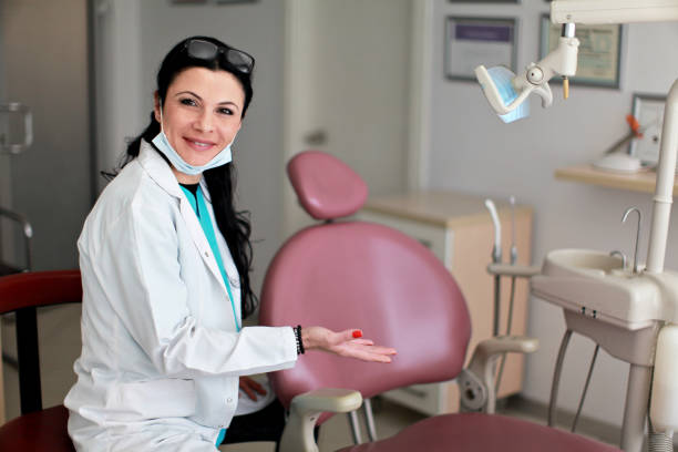a dentist showing the maroon colored dental chair